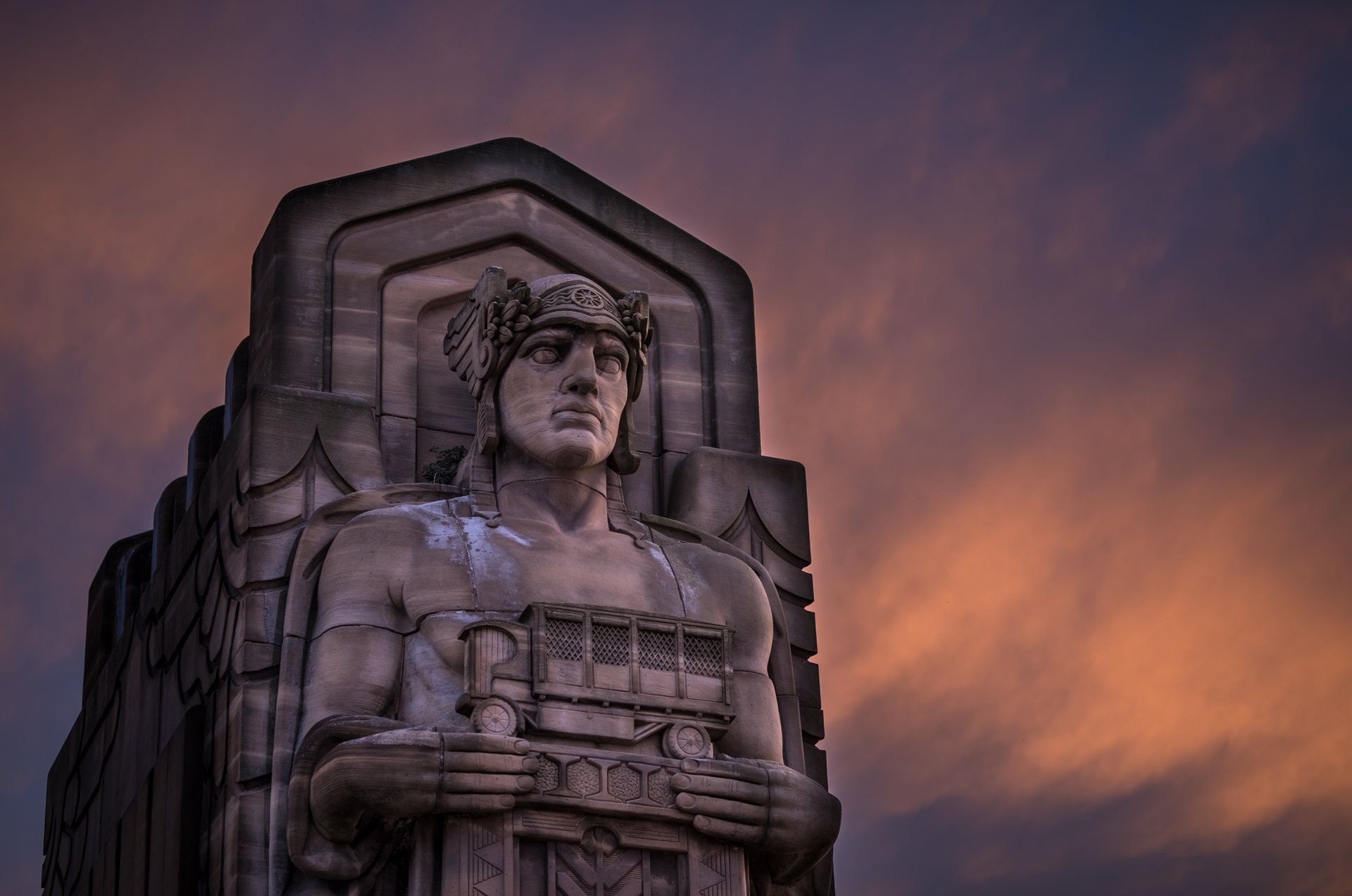 A Guardian of Traffic statue on the Hope Memorial Bridge in Cleveland, against a sunset sky