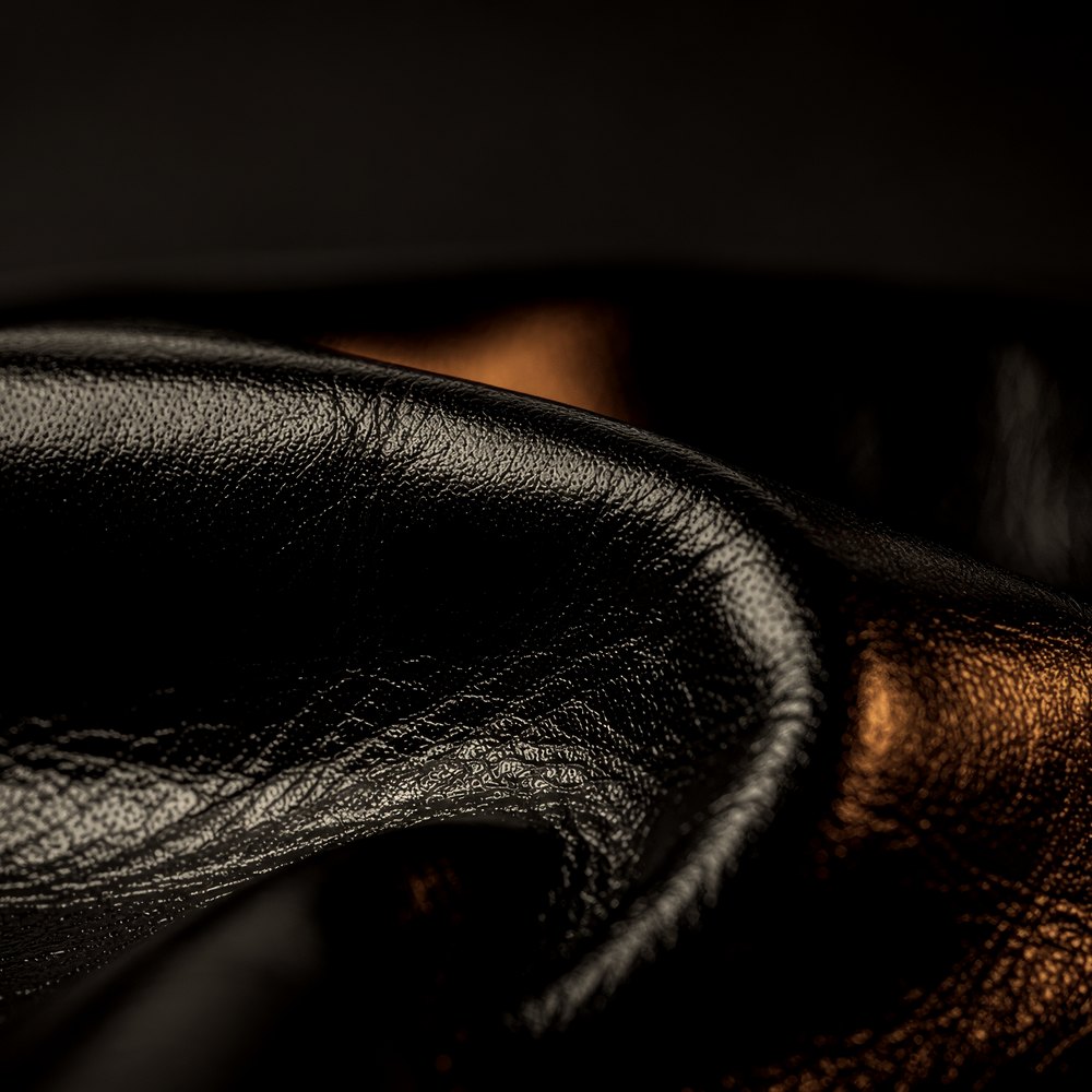Black leather catching a low amber light