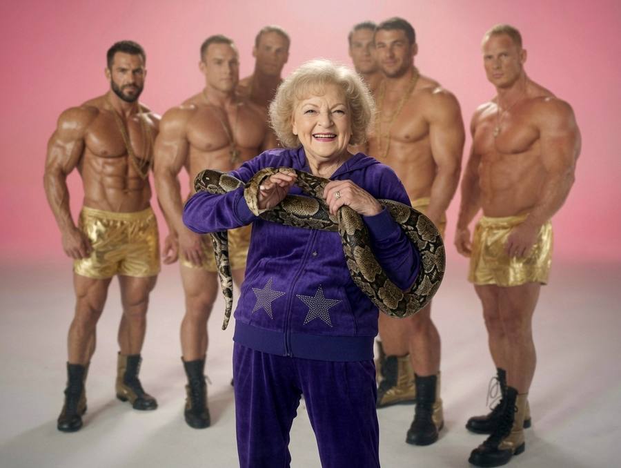 Betty White holding a snake, surrounded by bodybuilders — the “I’m Still Hot” shoot